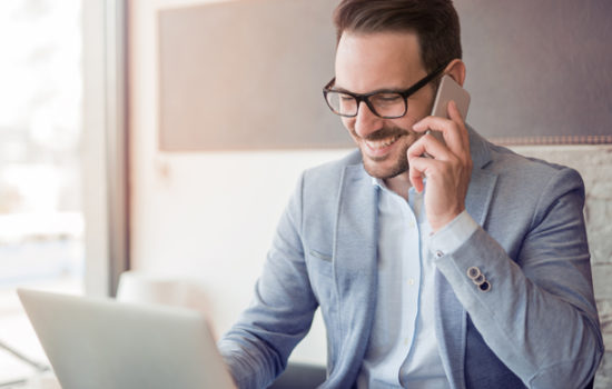 Young Male on His Cell Phone Fostering Client Relationships