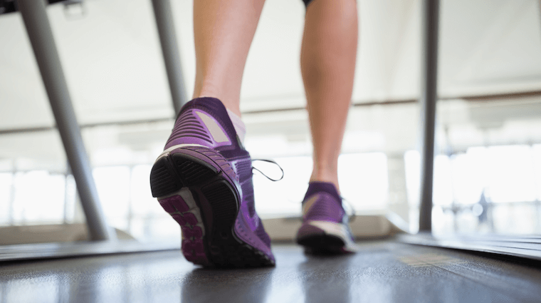 Female Leg and Feet Walking on a Treadmill in Fitness Center